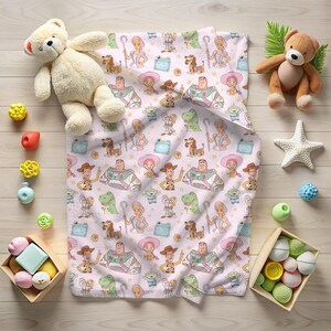 May include: A light pink baby blanket with a repeating pattern of cartoon characters. The blanket features a cowboy, a space ranger, a sheep herder, a green dinosaur, and other characters. Toys surround the blanket.