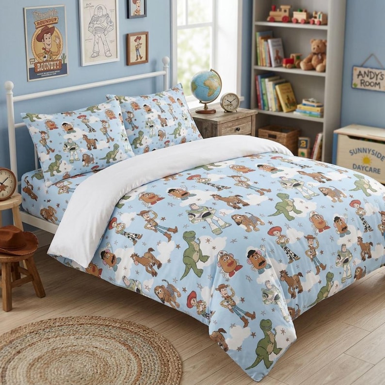 Puede incluir: Un juego de cama azul claro con un patr&oacute;n repetitivo de personajes de Toy Story, incluyendo a Woody, Buzz Lightyear, Rex y el Sr. Patata, intercalados con nubes blancas y peque&ntilde;as estrellas, junto con una funda n&oacute;rdica blanca lisa.