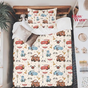 Puede incluir: Juego de cama con tem&aacute;tica de Cars en beige. El patr&oacute;n repetido presenta coches de dibujos animados rojos, azules y marrones, sem&aacute;foros y banderas a cuadros. Incluye funda n&oacute;rdica y funda de almohada, para dormitorio infantil.