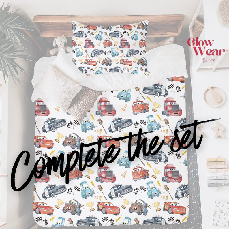 K&ouml;nnte beinhalten: Ein wei&szlig;es Bettw&auml;sche-Set mit einem bunten Automuster. Das Design umfasst verschiedene Cartoon-Autos, Schachflaggen und Troph&auml;en. Der Text "Complete the set" steht unten. Kissenbezug und Bettbezug sind sichtbar.