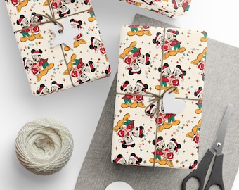 Puede incluir: Papel de regalo con un patrón repetitivo de Mickey y Minnie Mouse con gorros de Papá Noel y ropa de invierno, acentuado por luces de colores y pequeñas estrellas sobre un fondo crema, atado con cordel y etiquetas blancas.