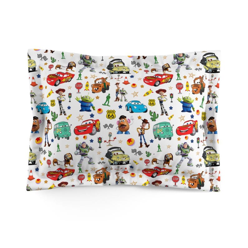 May include: A rectangular pillowcase featuring a white background with a repeating pattern of characters from the Cars and Toy Story movies, including Lightning McQueen, Mater, Woody, Buzz Lightyear, Mr. Potato Head, and green army men.