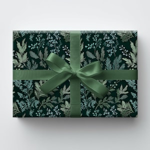May include: A wrapped gift box with a dark green floral pattern and a matching green ribbon tied in a bow. The gift wrap features a repeating design of stylized leaves and branches in shades of green and gold.