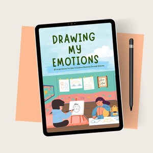 May include: A digital tablet shows the cover of a children's workbook titled "Drawing My Emotions." The cover features illustrations of children drawing and the text "A Fun Workbook For Kids to Explore Emotions Through Drawing." A black stylus rests beside the tablet.
