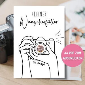 Könnte beinhalten: Schwarz-Weiß-Strichzeichnung einer Kamera, die von Händen gehalten wird, mit den Worten "oh snap!" und deutschem Text. Ein rosa Kreis mit deutschem Text befindet sich in der unteren rechten Ecke. Im Hintergrund ist eine Kamera zu sehen.