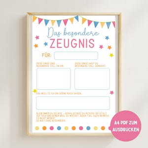 Puede incluir: Una impresión enmarcada con un marco de madera clara. La impresión tiene un fondo blanco con texto colorido y decoraciones de estrellas. El texto incluye secciones para completar y las palabras "Das besondere ZEUGNIS". Un círculo rosa con texto está en la esquina inferior derecha.