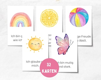 Pode incluir: Um conjunto de 32 cartões de afirmação em aquarela. Cada cartão apresenta uma ilustração colorida, incluindo um arco-íris, uma fatia de limão, uma bola de praia, um sol sorridente e uma borboleta. Texto em alemão é visível.