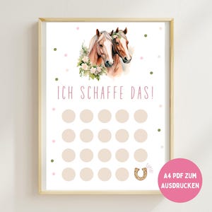 以下が含まれることがあります： 花で飾られた2頭の馬の水彩画イラストが描かれたフレームプリント。「ICH SCHAFFE DAS!」というドイツ語のテキストが、一連の円の上に表示され、蹄鉄のグラフィックが下部にあります。テキスト入りのピンク色の円が右下にあります。