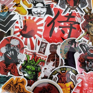 Puede incluir: Una colección de pegatinas coloridas con caracteres japoneses, guerreros samuráis y otras imágenes tradicionales japonesas. Las pegatinas están impresas en papel blanco y tienen un acabado brillante.