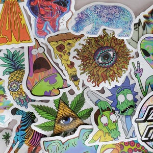 Può includere: Una collezione di adesivi psichedelici colorati con vari disegni, tra cui una fetta di pizza, un ananas, un gatto, una zebra, un alieno, un sole con un occhio e un personaggio dei cartoni animati. Gli adesivi sono tutti su uno sfondo bianco.