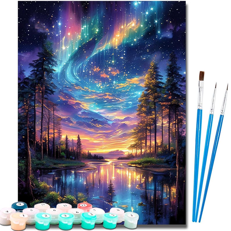 May include: A paint-by-numbers kit depicting a colourful landscape with a starry night sky, a river, and trees. The kit includes numbered paint pots and three paintbrushes with blue handles. The artwork shows a vibrant aurora borealis.