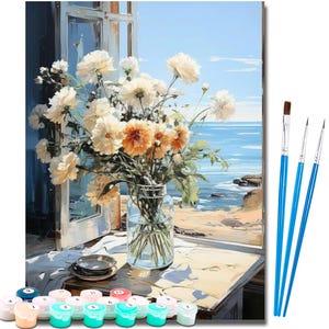 May include: A paint-by-numbers kit featuring a floral still life with a coastal view. The painting depicts a bouquet of white and orange flowers in a glass jar, set on a table near an open window. Includes paint pots and paint brushes.