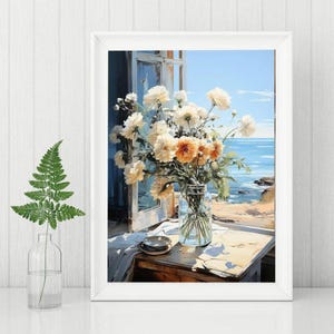 May include: A framed painting depicts a vase of white and orange flowers on a table by an open window overlooking the ocean. A fern in a glass bottle is in the foreground. The painting has a soft, impressionistic style.