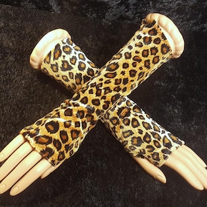 以下が含まれることがあります： 茶色と黒のヒョウ柄のベルベット製ロングアームウォーマーのペア