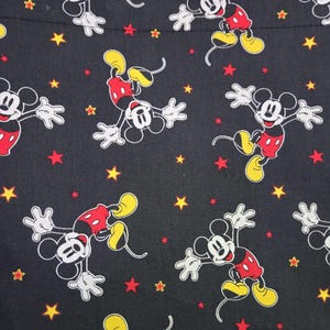 May include: Black tote bag featuring a repeating pattern of Mickey Mouse in various poses. The design includes red, yellow, and white Mickey Mouse figures, along with red and yellow stars scattered across the black background.