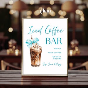 May include: A framed sign with the words "Iced Coffee BAR" in teal script. An illustration of an iced coffee drink with a blue bow and whipped cream is featured. Instructions read "Add Ice, Pour Coffee, Top with Creamm, Sip, Savor & Enjoy."