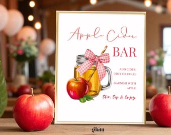 Puede incluir: Un letrero enmarcado con las palabras "Apple Cider BAR" en escritura roja. El letrero presenta una ilustración de un tarro lleno de sidra, una manzana roja y un lazo rosa a cuadros. El letrero dice "Añadir sidra (caliente o fría), decorar con manzana, remover, beber y disfrutar."