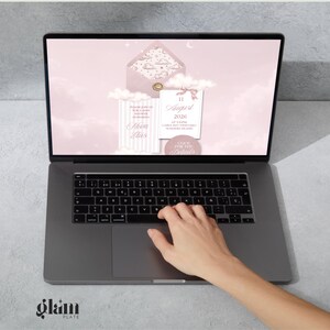 May include: A laptop displaying a pink invitation design with clouds, an envelope, and text that reads "11 August 2026". The laptop is open, and a hand is touching the trackpad. The Glam Plate logo is visible in the bottom left corner.