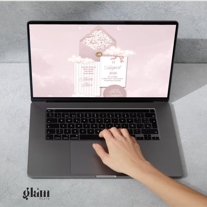 May include: A laptop displaying a pink invitation design with clouds, an envelope, and text that reads "11 August 2026". The laptop is open, and a hand is touching the trackpad. The Glam Plate logo is visible in the bottom left corner.
