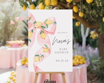 May include: A white welcome sign with a pink bow decorated with lemons and green leaves. The sign reads "Welcome to Nova's Baby Shower 04.15.25".