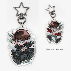 May include: Two-sided keychain depicting a cartoon character with brown hair and glasses, wielding a weapon. The keychain has a star-shaped clasp. The text "Two-Sided Keychain" is also visible.