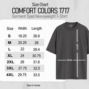 Peut inclure: Un t-shirt gris fonc&eacute; Comfort Colors 1717 Garment Dyed Heavyweight avec un tableau des tailles. Le tableau indique les tailles S-4XL avec des mesures de largeur et de longueur en pouces. Le t-shirt a un col rond et des manches courtes.