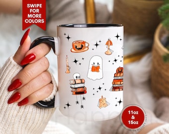 May include: White ceramic mug with a black handle and rim, decorated with Halloween-themed illustrations. The design includes a jack-o'-lantern, ghost, candles, and books. The mug is available in 11oz and 15oz sizes and is dishwasher safe.