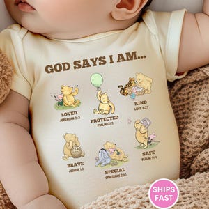 May include: A light yellow baby bodysuit with the text "GOD SAYS I AM..." and illustrations of Winnie the Pooh characters. The bodysuit also includes the words "LOVED", "PROTECTED", "KIND", "BRAVE", "SAFE", and "SPECIAL".