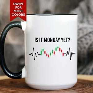 May include: White ceramic mug with a black handle and rim. The mug features the text "IS IT MONDAY YET?" above a black line graphic with red and green candlestick chart elements, resembling a heartbeat.