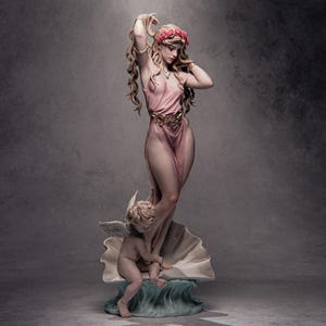 May include: A detailed figurine featuring a standing woman with long blonde hair adorned with a red floral crown, wearing a pale pink dress with a gold waist ornament, accompanied by a small winged cherub sitting on a large seashell base.