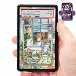 Op de afbeelding: Een beoordeelde Pokémon Charmander-kaart, gepresenteerd in een zwarte houder. De kaart toont een kleurrijke illustratie van een raamscène. De tekst geeft aan dat deze uit de Obsidian Flames-set komt. Een paarse en witte Lost Moon-pin is zichtbaar.