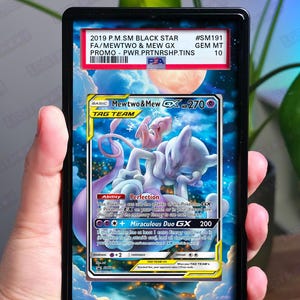 May include: A graded Pokémon trading card featuring Mewtwo & Mew GX. The card has a colorful illustration of the two Pokémon against a blue sky background. The card is encased in a black holder with text indicating it is a 2019 P.M.SM Black Star promo.