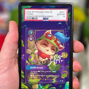 May include: A graded trading card featuring a colorful illustration of Teemo from League of Legends. The card is encased in a black holder with text indicating it's a 2025 Riftbound OGN EN Signature Overnumber, graded GEM MT 10.