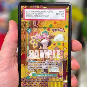 May include: A trading card featuring Jewelry Bonney with special alternate art. The card is encased in a protective holder. The card has a gold and purple background with the text "SAMPLE" across the front. The card's details include the Lostmoon Displays logo and card number.