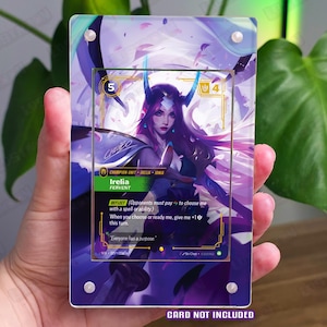 May include: A rectangular acrylic display case featuring a purple and blue abstract design with a central cutout for a trading card. The case has four silver corner screws and includes the text CARD NOT INCLUDED printed in purple at the bottom.