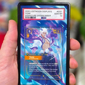May include: A Yone trading card in a protective case. The card features a character illustration with purple and blue accents. Text on the card includes "Yone" and "Blademaster". The case has a label with text.