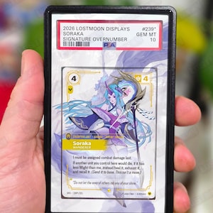 Può includere: Una carta collezionabile con Soraka della serie 2026 Lostmoon Displays, signature overnumber. La carta è classificata GEM MT 10 e include il testo "Do not let the envy of others rob you of your shine."