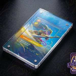 May include: A rectangular clear acrylic display case featuring a card titled Keeper of the Hammer. The card displays a character illustration, game text, and a pink signature. The case is secured with four silver metal corner screws.