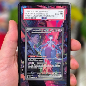 May include: A PSA graded trading card featuring Team Rocket's Mewtwo ex, labelled 2025 POKEMON DRI EN #231 GEM MT 10. The card displays a purple Mewtwo and a human character against a vibrant pink and blue urban background with game text.