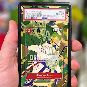 Può includere: Una carta collezionabile con Roronoa Zoro di One Piece. La carta presenta un'illustrazione colorata del personaggio con il testo "2024 One Piece Roronoa Zoro English Version 1st Anv Set." La carta è valutata GEM MT 10.
