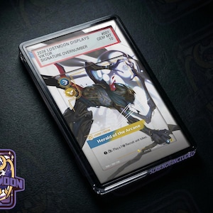 Può includere: Una carta collezionabile rettangolare in una custodia protettiva trasparente. La carta presenta un'illustrazione di una creatura scura e stilizzata, il testo "Herald of the Arcane" e un'etichetta "2026 LOSTMOON DISPLAYS VIKTOR SIGNATURE OVERNUMBER #001 GEM MT 10."