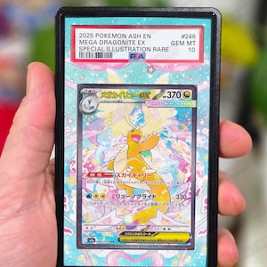 Op de afbeelding: Een beoordeelde Pokémon-kaart met Mega Dragonite EX. De kaart heeft een speciale illustratie met een kleurrijk ontwerp en Japanse tekst. De kaart is ingesloten in een zwarte houder met de tekst "2025 POKEMON ASH EN" en "GEM MT 10".