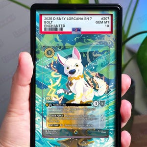 Può includere: Una carta Disney Lorcana Bolt valutata, raffigurante un cane bianco con un collare giallo ed effetti di fulmini. La carta è racchiusa in un supporto nero con la scritta "2025 DISNEY LORCANA EN 7 BOLT ENCHANTED".