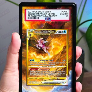 May include: A graded Pokémon card featuring Origin Forme Palkia VSTAR. The card is encased in a black holder with a PSA label indicating a GEM MT 10 grade. The card has a gold and blue color scheme with the text "2023 POKEMON SWSH ORGN.FRM.PALKIA VSTAR CROWN ZENITH-FA-SECRET".