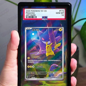 Può includere: Una carta Pokémon valutata in una custodia nera. La carta presenta Pikachu e Gengar con testo giapponese. La custodia ha un'etichetta PSA con il testo "2025 Pokemon 151 CS Pikachu Art Rare #172 GEM MT 10". La parte inferiore recita "CARD NOT INCLUDED".