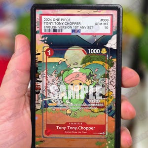 May include: A graded trading card featuring Tony Tony Chopper from One Piece. The card has a colorful illustration of the character with Japanese-inspired artwork. The card is in a protective case with text that reads "2024 ONE PIECE TONY TONY.CHOPPER ENGLISH VERSION 1ST ANV SET".