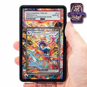 Può includere: Una carta Pokémon valutata con Greninja ex, un'illustrazione speciale rara. La carta è racchiusa in un supporto nero con il testo "2024 Pokemon TWM EN" e "GEM MT 10". È visibile una spilla "Lost Moon".