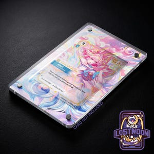 Può includere: Un espositore per carte rettangolare in acrilico trasparente con uno sfondo olografico dai toni pastello vorticosi in rosa, blu e giallo. La custodia è fissata con quattro viti metalliche color argento agli angoli e contiene una carta da gioco.