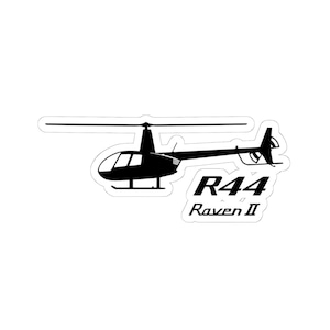 Könnte beinhalten: Schwarz-weißer Aufkleber mit einer Hubschraubersilhouette. Der Aufkleber zeigt den Text "R44 Raven II" in einer speziellen Schriftart, mit Haupt- und Heckrotor.