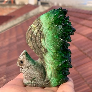 May include: A green crystal squirrel figurine with a detailed carved body and a bushy tail made of green crystals.